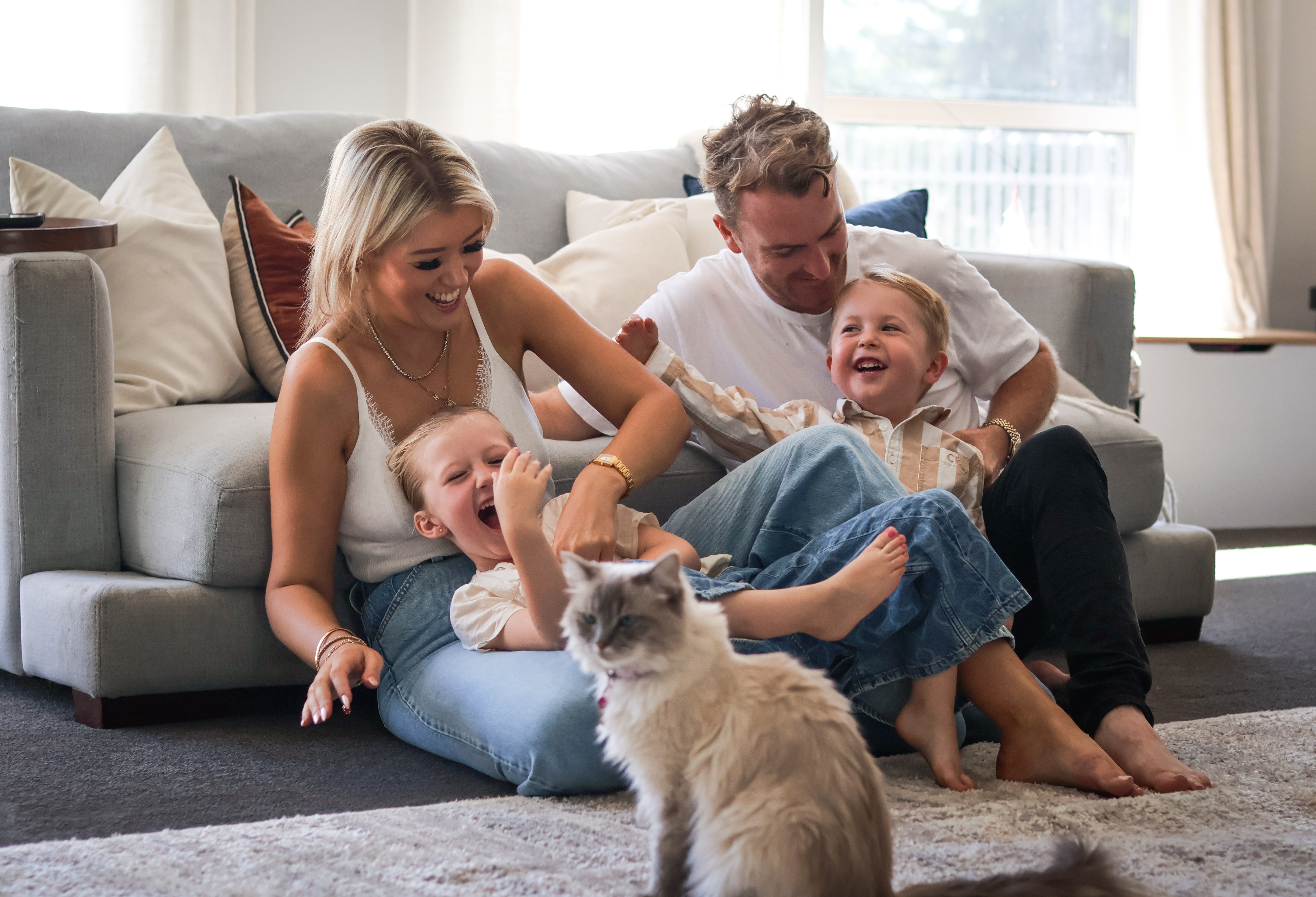 The Higgs family smiling together, parents with their two young children